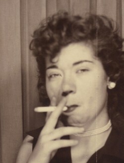 Woman smoking a cigarette, 1953